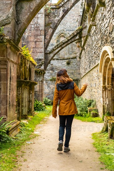 A young woman visiting the gardens inside the Abbaye de Beauport in the village of Paimpol