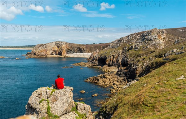A young man in a red shirt on the coast enjoying the summer at Le Chateau de Dinan on the Crozon peninsula in French Brittany