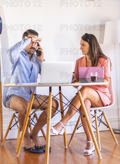 A couple teleworking at home