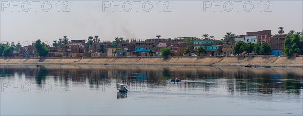 Traditional Egyptian villages on the bank of the river Nile. Views sailing on the cruise on the river Nile from Luxor to Aswer