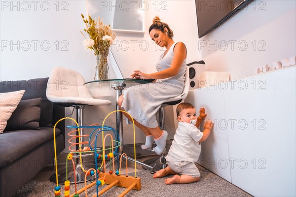 Young Caucasian mother caring for her young son and teleworking