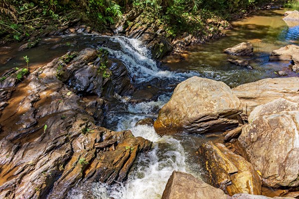 Stream of calm waters between rocks and surrounded by vegetation