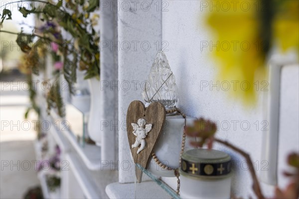 Wooden heart with an angel on a grave in a cemetery in Sardinia