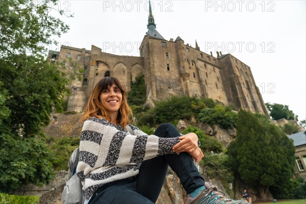 A young tourist visiting the famous Mont Saint-Michel Abbey in the Manche department