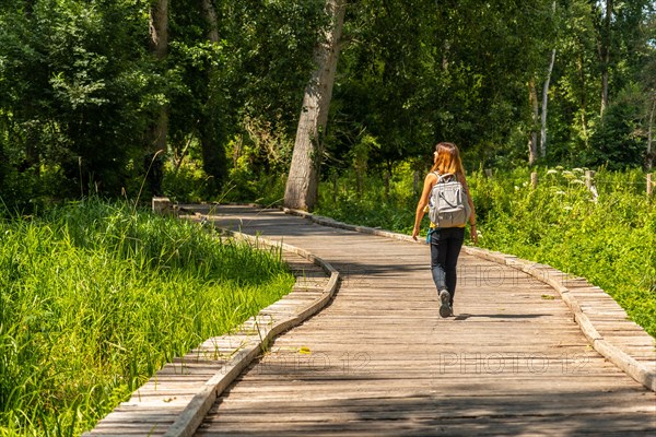 A young woman on the footpath along a footbridge between La Garette and Coulon