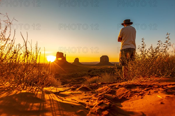 A lifestyle boy with a hat at dawn in Monument Valley