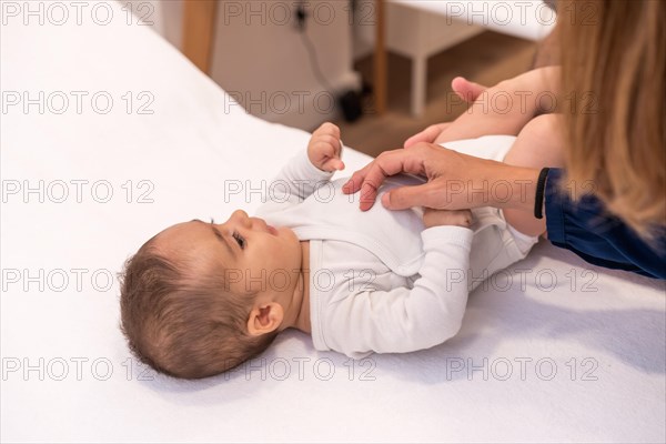Close-up photo of a mother playing with a baby during a medical exam