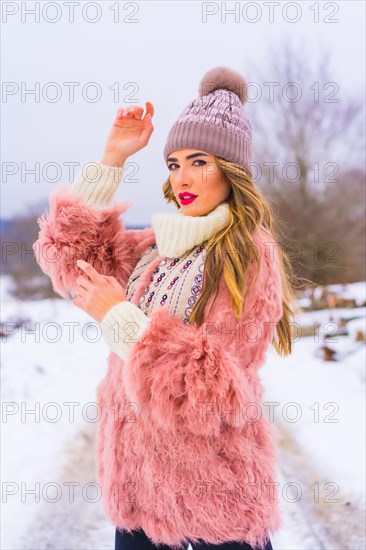 Portrait of young blonde model wearing pink fur jacket