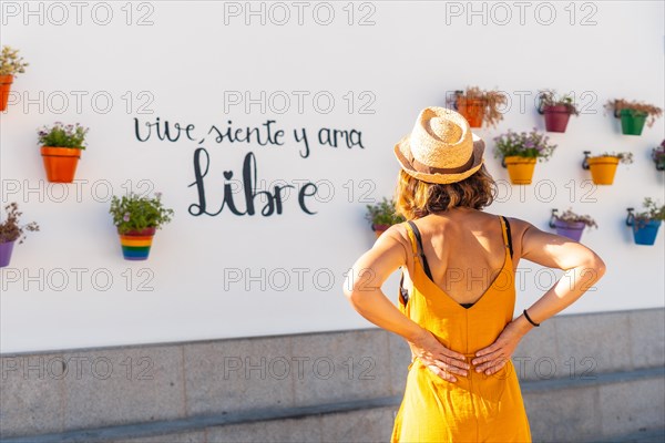 A tourist in pots with flowers with rainbow colors with lgbt colors. Mijas