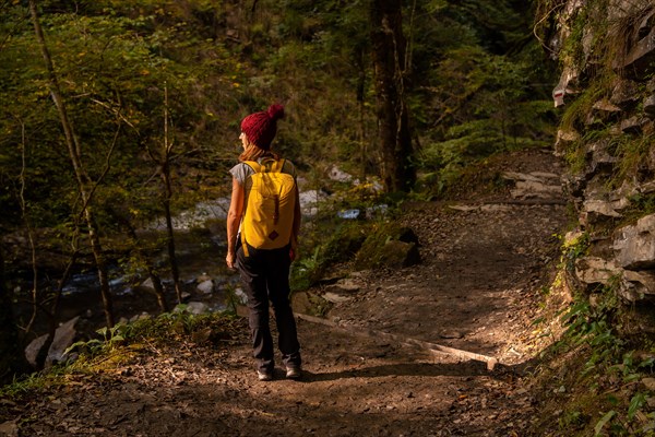 A young woman at sunset on the path to the Holtzarte suspension bridge