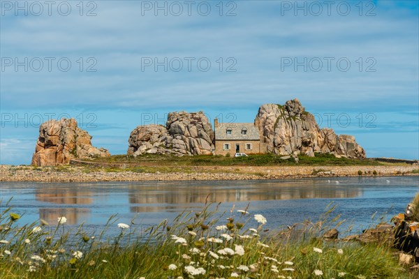 House between rocks next to a beautiful lake