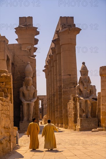 Two local men visiting the Egyptian Temple of Luxor and its precious column