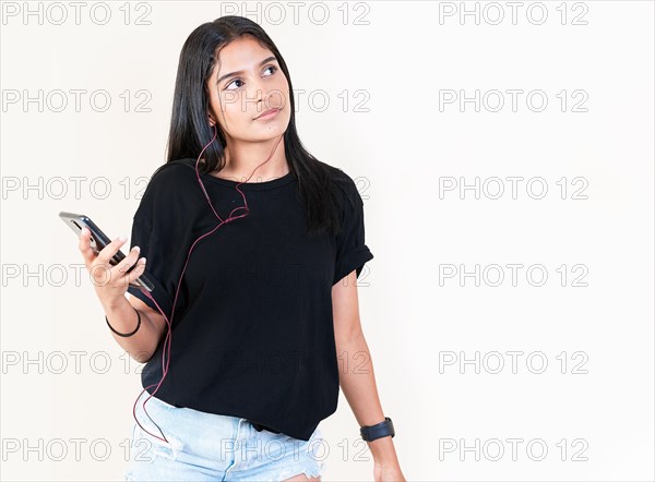 Portrait of beautiful girl listening to music with smartphone isolated. Happy latin gir listening to music with cell phone. Latin girl enjoying music with phone isolated