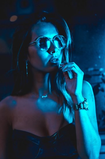 Brunette model at night in the city with blue leds