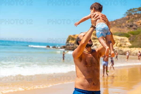 Father playing in the sand and having fun with son