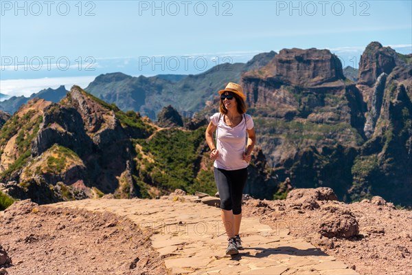 A tourist walking on the trekking trail at Pico do Arieiro in summer