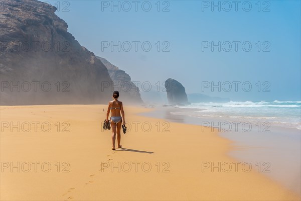 A young woman in the Roque del Moro of the Cofete beach of the natural park of Jandia