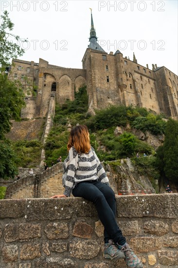 A young tourist visiting the famous Mont Saint-Michel Abbey in the Manche department