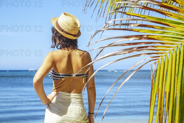 A young woman with a hat on West End beach on Roatan Island. Honduras