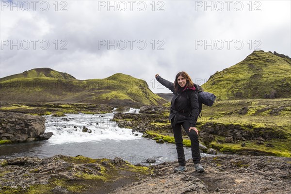 A young woman in a large river from the 54 km trek from Landmannalaugar