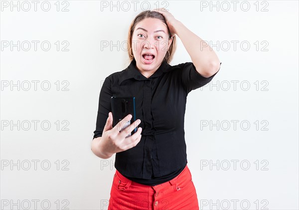 Astonished girl with cell phone holding head isolated. Young woman stunned holding head and cell phone with copy space