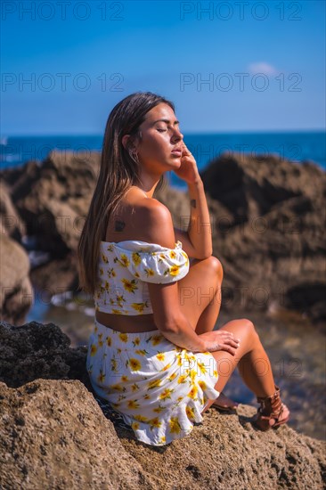 Portrait of a young woman in a white dress on the beach