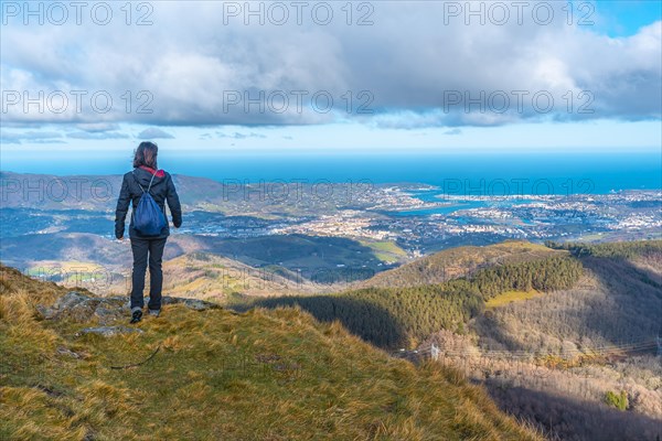 A young mountaineer looking at the village of Fuenterrabia from the mountain of Aiako Harria