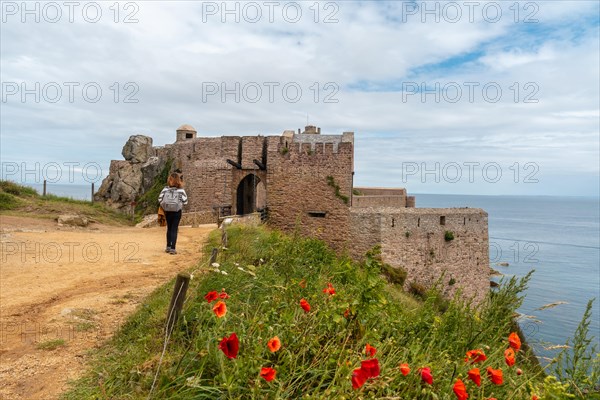 A young tourist visiting Castle Fort-la-Latte by the sea at Cape Frehel and near Saint-Malo