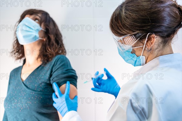 Coronavirus vaccine applied to a young woman by a doctor. Antibodies
