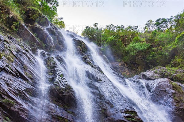 Cascade of clear water running between the rocks and the forest in Minas Gerais