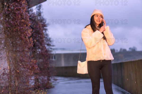 Young pretty Caucasian brunette walking in the city in winter