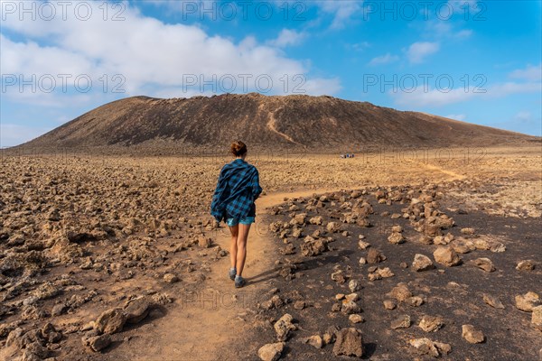 A young woman on the trail to the Crater of the Calderon Hondo volcano near Corralejo