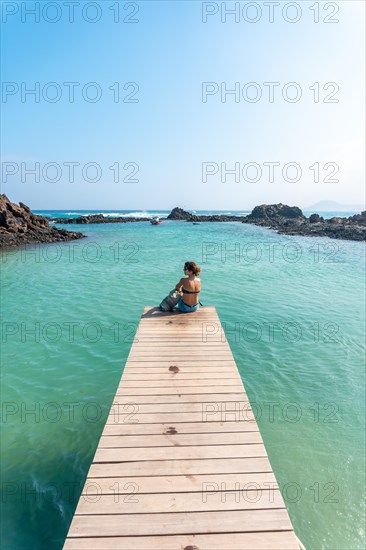 A young woman walking along the wooden walkway on the Isla de Lobos