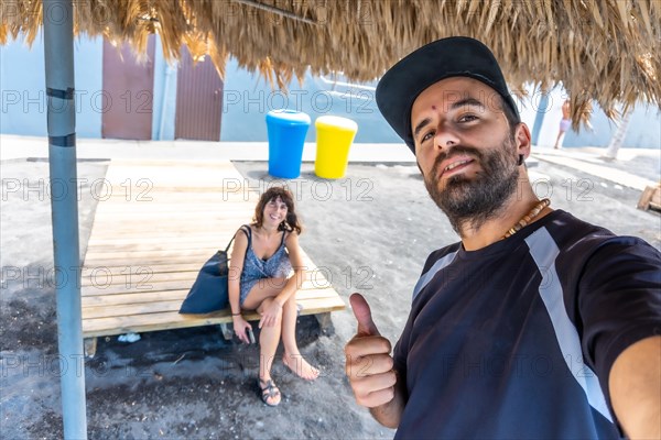 A tourist couple enjoying the beach of Puerto Naos on the island of La Palma in summer. Canary islands spain