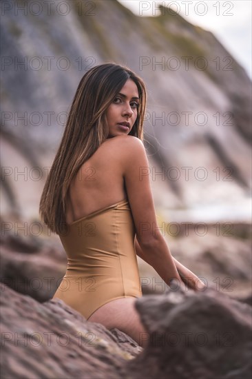 Portrait of a brunette woman with a swimsuit on a beach in summer