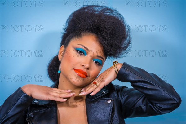 A closeup portrait of a fashion attractive rocker style woman with bright makeup wearing a leather jacket