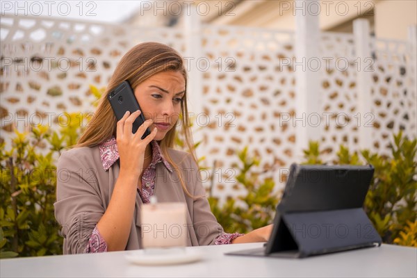 Portrait of an executive and businesswoman having breakfast in a restaurant talking on the phone and a tablet