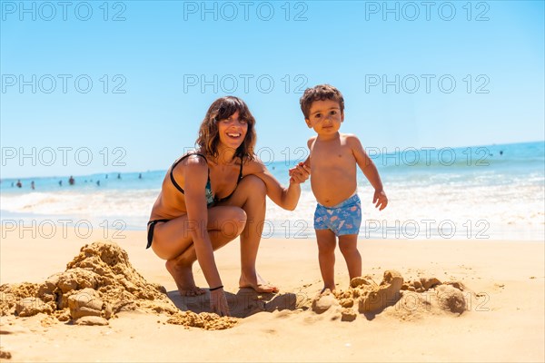 Mother and son on the beach at Praia do Barranco das Belharucas