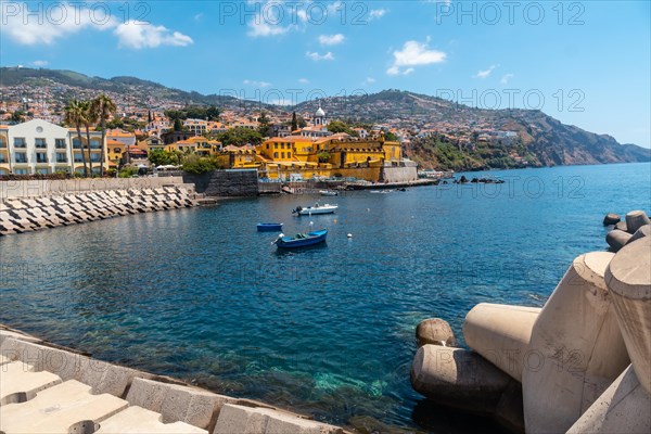 Small fishing boats next to the Forte de Sao Tiago on the beach of Funchal