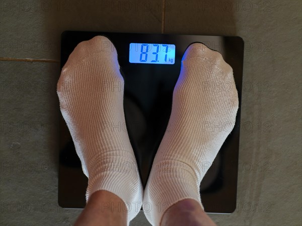 Feet with white socks on personal scale