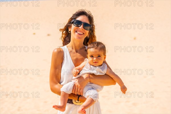 Young mother with her son in the dunes of the Corralejo Natural Park