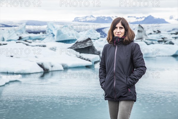 A young brunette tourist on the frozen lake of Joekulsarlon in August. Iceland