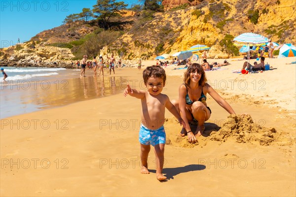 Playing in the sand on the beach at Praia do Barranco das Belharucas