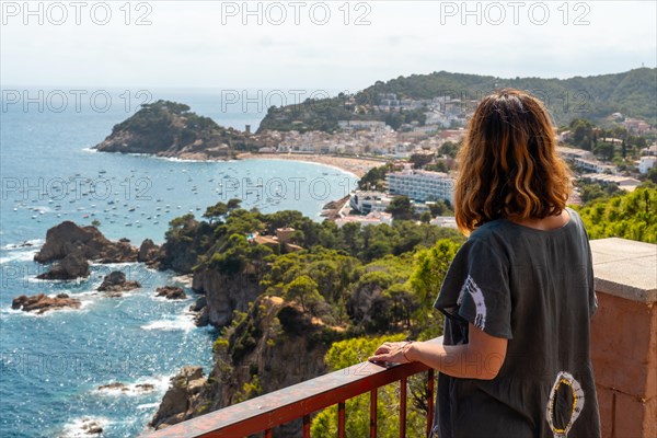 A young tourist looking at Tossa de Mar from the viewpoint