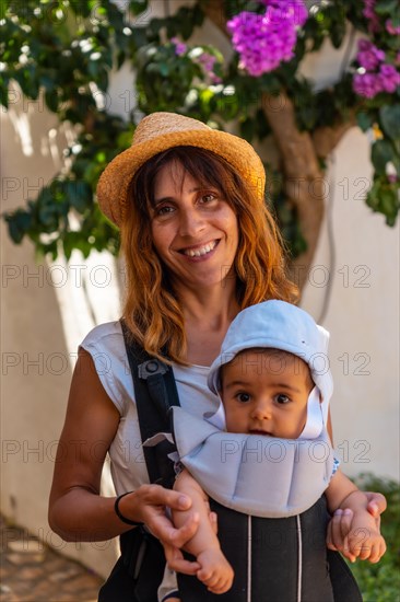 A mother walking with her baby through the town of Sa Tuna on the coast of Begur in summer