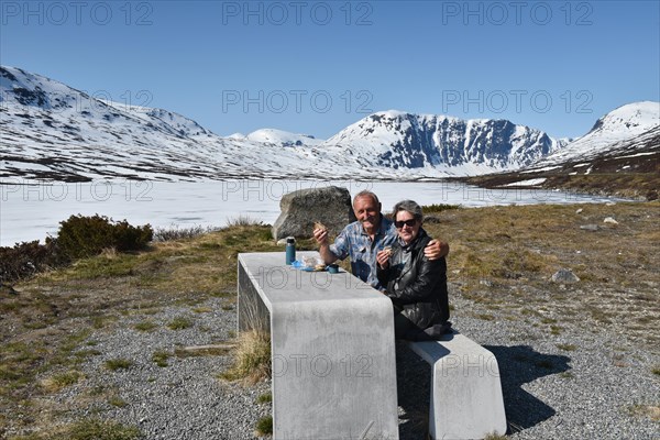 Couple having a picnic by an icy lake near Stryn