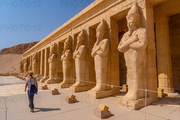 A young woman with pharaoh sculptures entering Hatshepsut's Funerary Temple in Luxor. Egypt