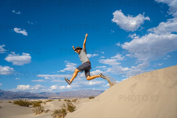 A young man jumping in desert on a summer afternoon in Death Valley