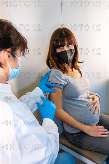 Female doctor applying the coronavirus vaccine to a pregnant woman. Antibodies