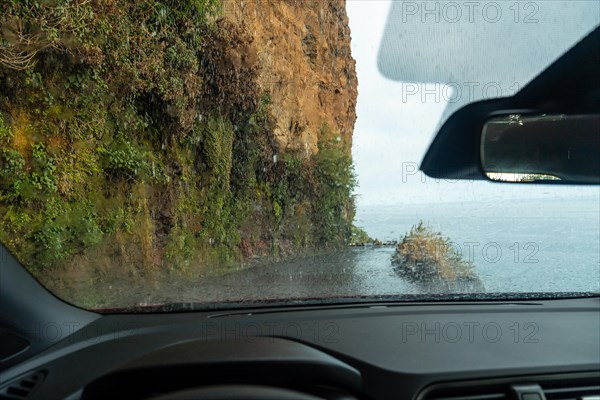 Water on top of the car driving inside a car at Anjos Waterfall